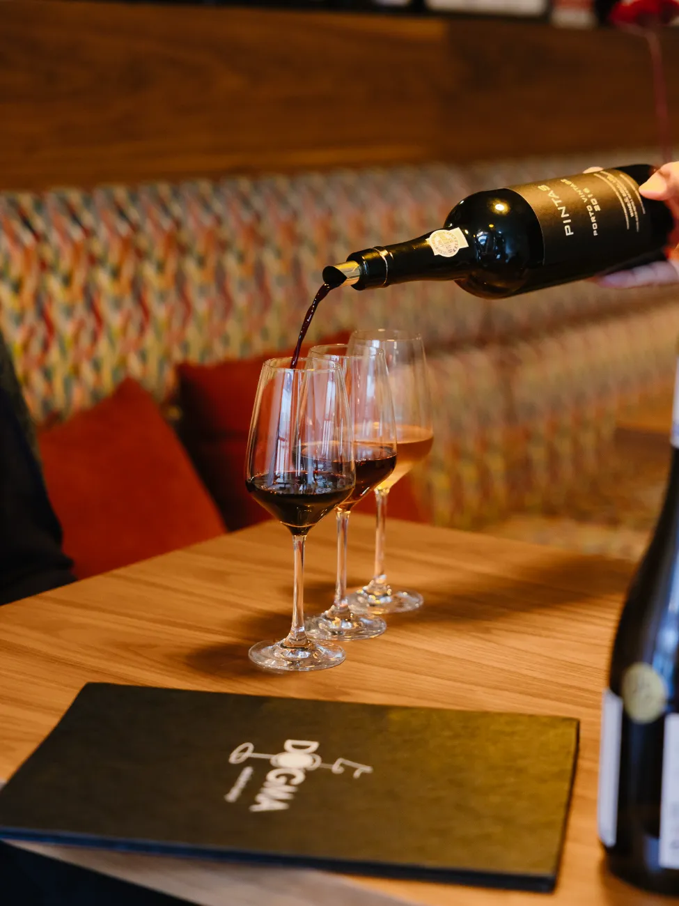 Red wine poured into two glasses at the table