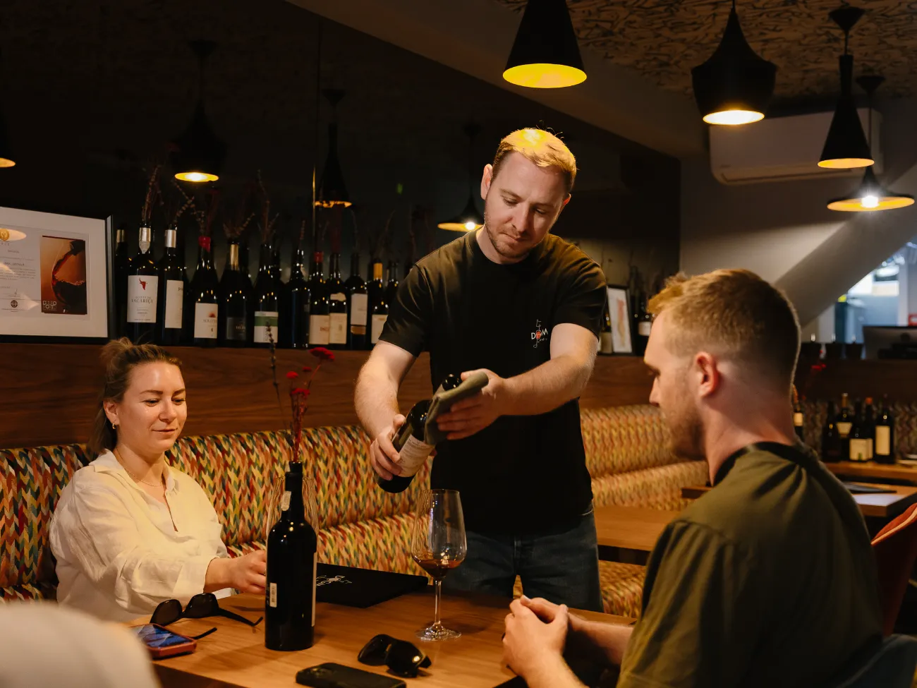 Opening a bottle for guests at the banquette