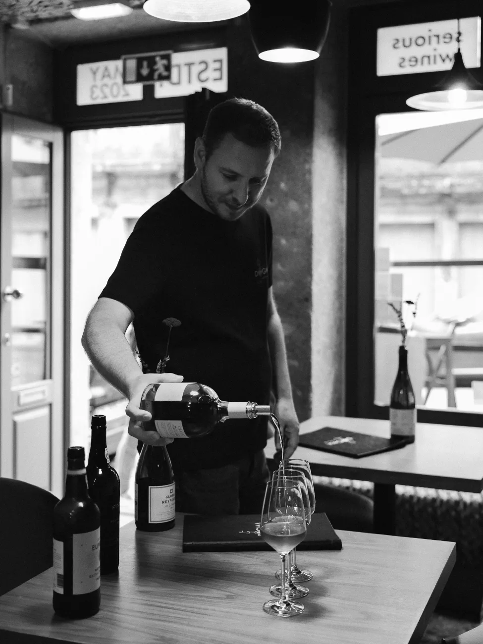 Pouring wine at the bar, in black and white