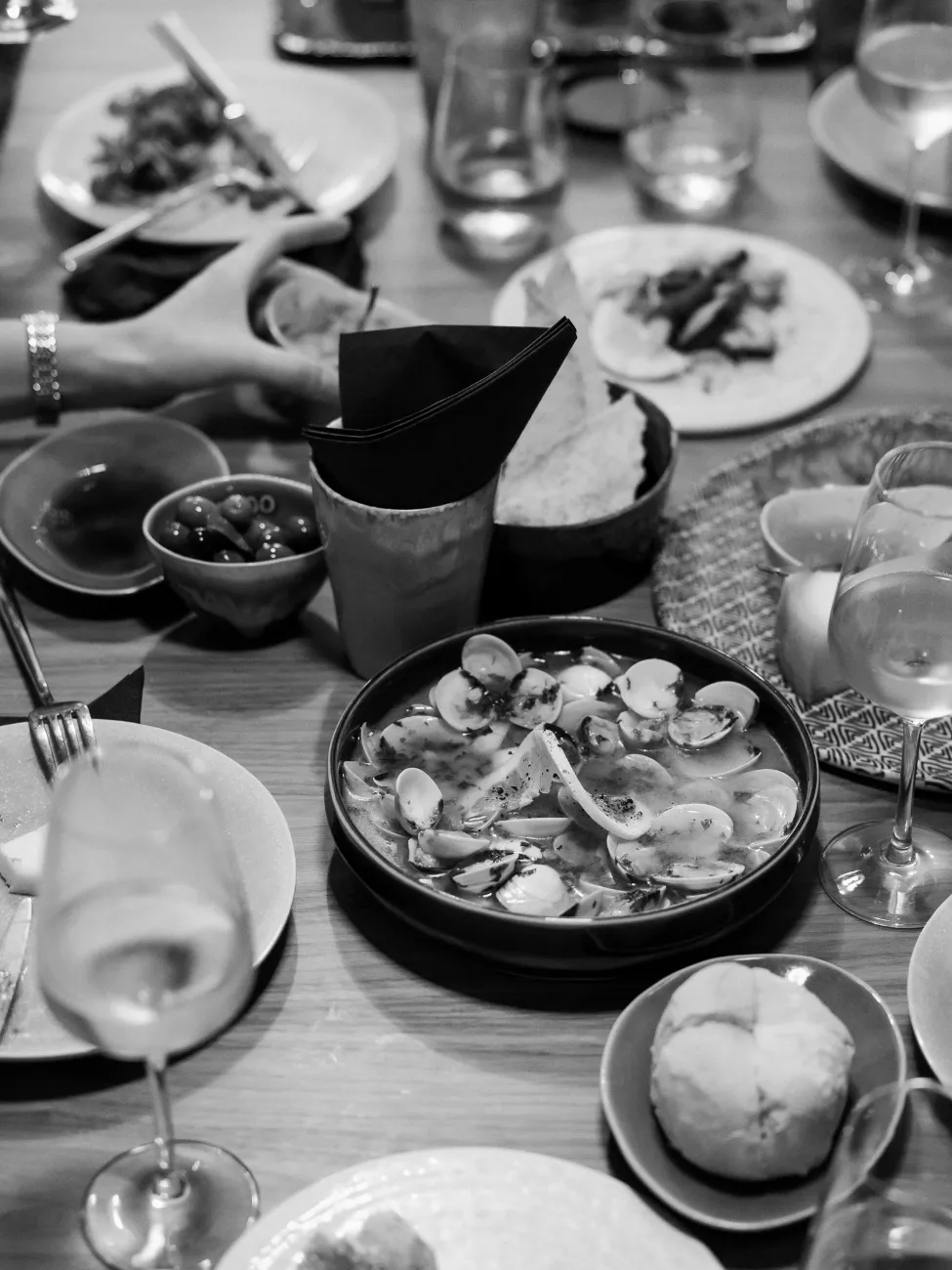 Clams, bread and small plates from above, in black and white