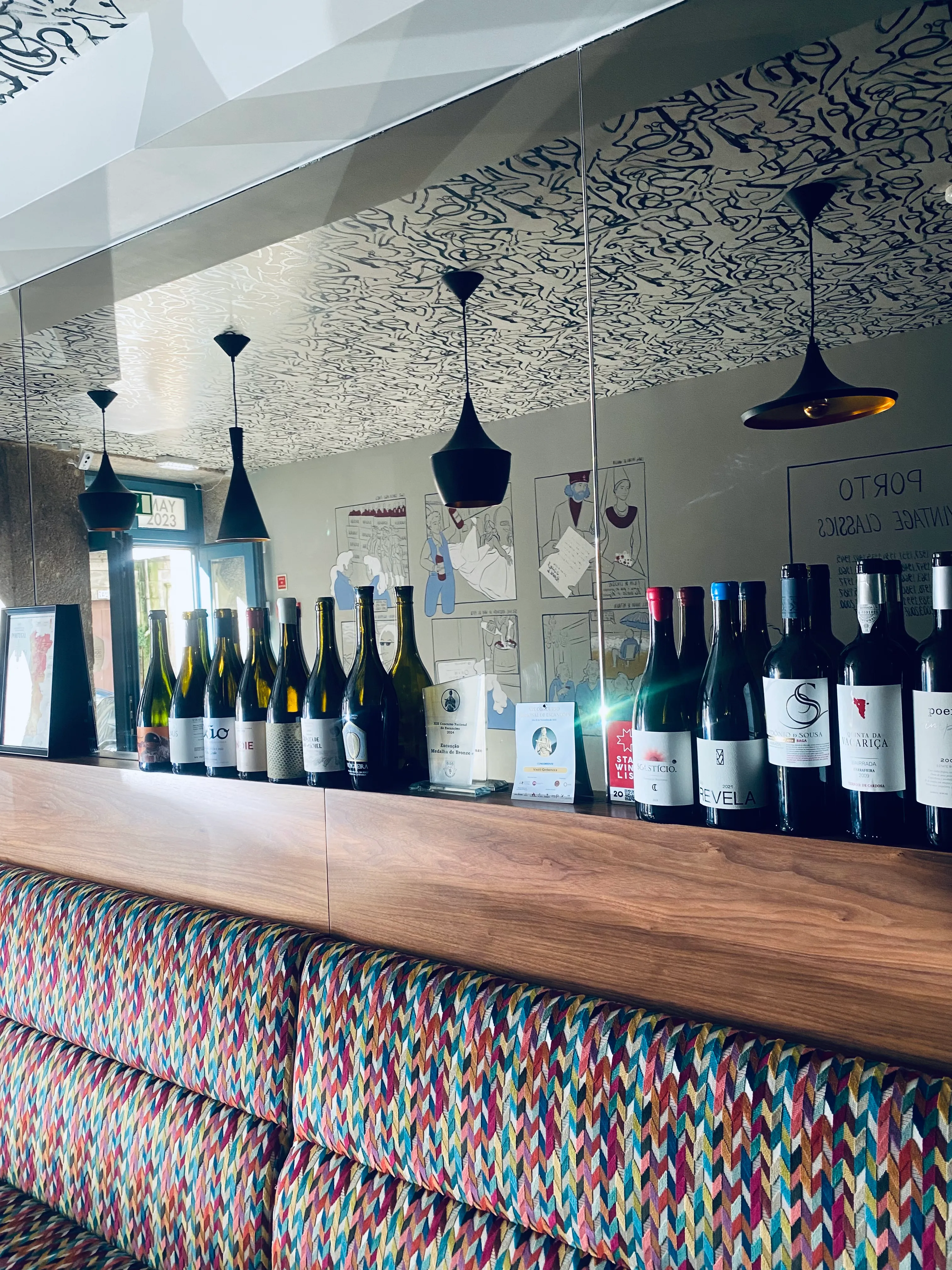 A curated shelf of wine bottles and awards at Dogma