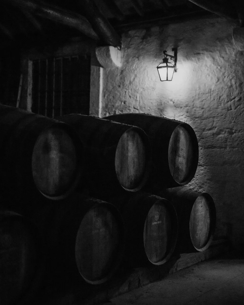 Port pipes aging under a lantern in a dark cellar, black and white