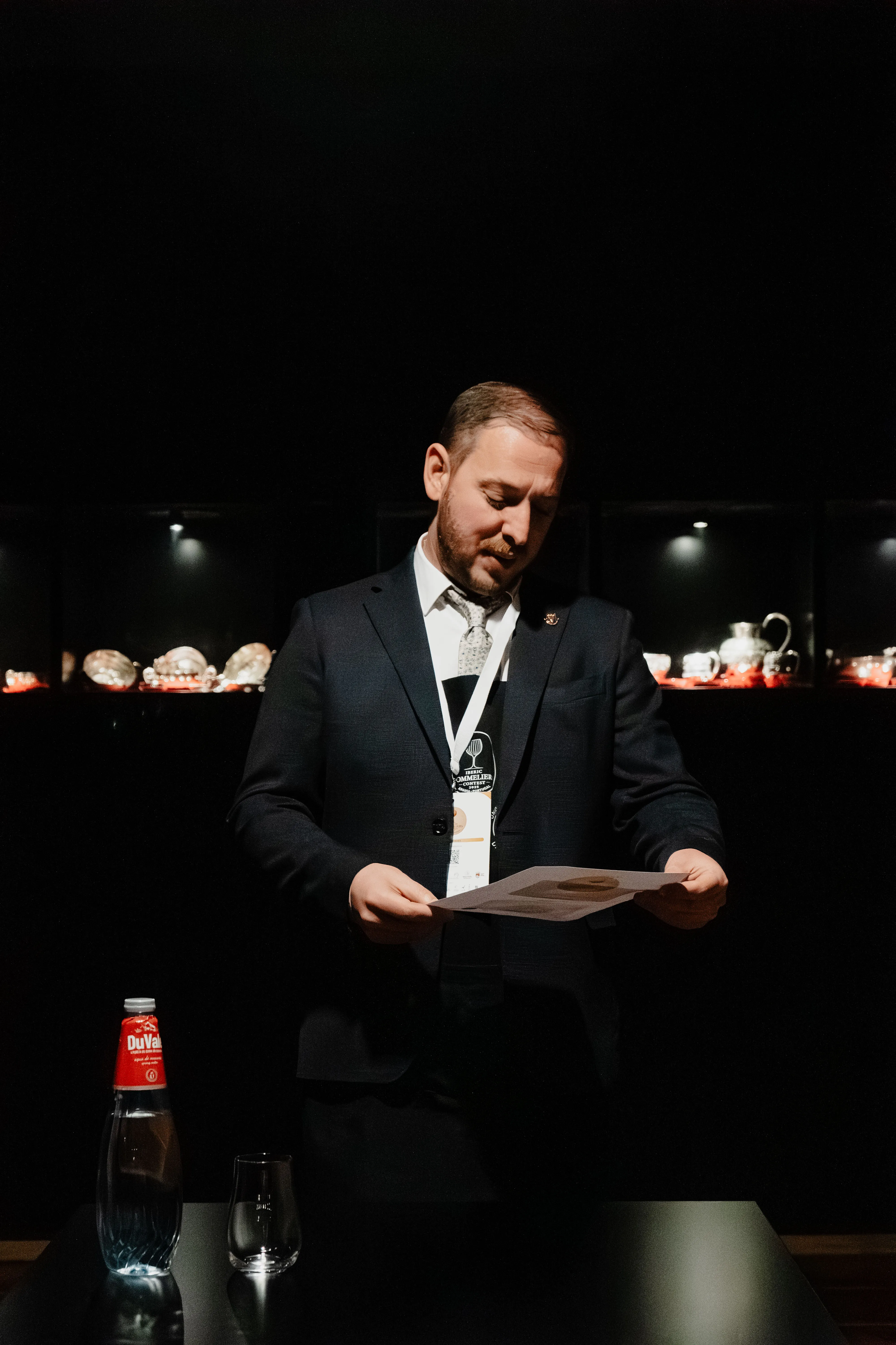 Vasilii Grebencea assessing a glass on stage at the National Sommelier Championship